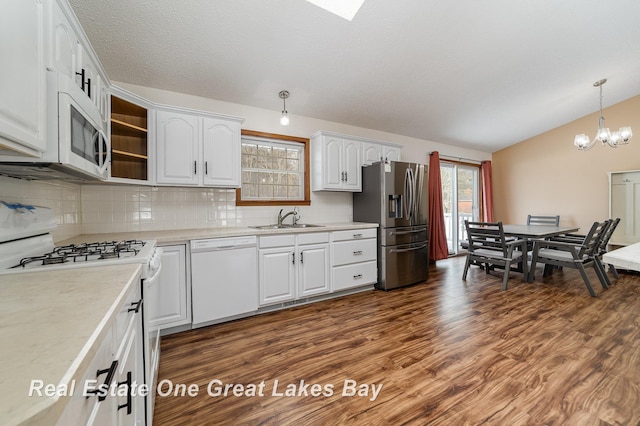 kitchen featuring pendant lighting, sink, white cabinets, tasteful backsplash, and white appliances