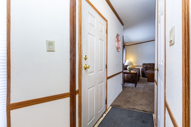 hall with ornamental molding and carpet flooring