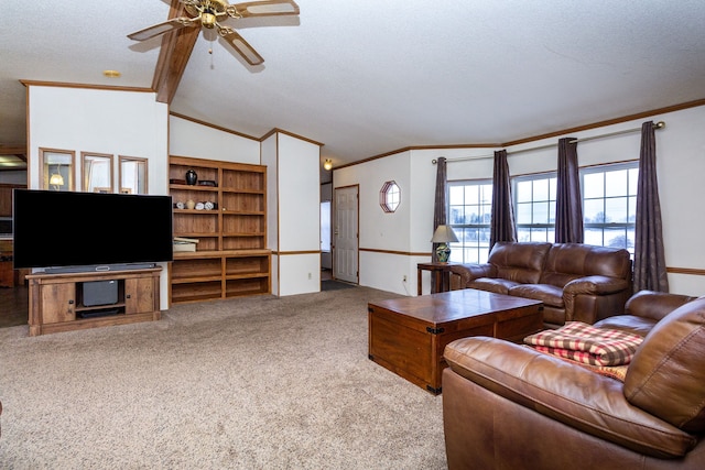 living room with ceiling fan, vaulted ceiling with beams, ornamental molding, a textured ceiling, and light colored carpet