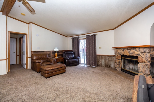 carpeted living room featuring lofted ceiling, a textured ceiling, ornamental molding, ceiling fan, and a fireplace