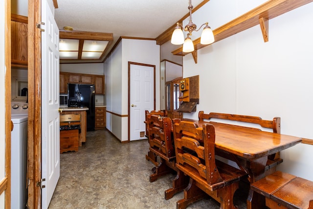 dining space with washer / clothes dryer, crown molding, and a notable chandelier