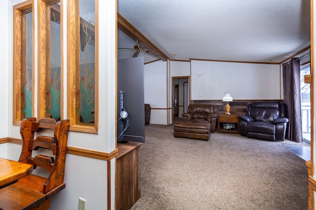 carpeted living room featuring ceiling fan, ornamental molding, vaulted ceiling, and a textured ceiling