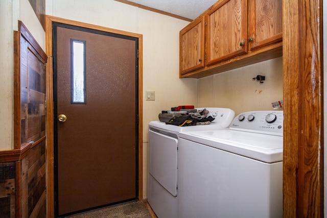 clothes washing area with cabinets and washing machine and dryer