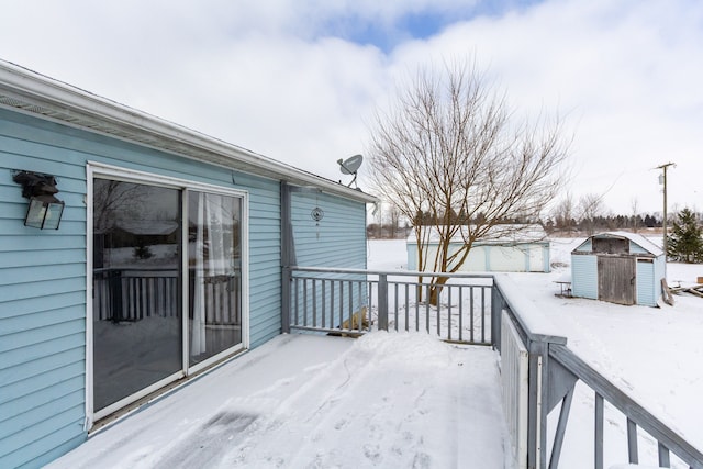 snow covered deck featuring a shed