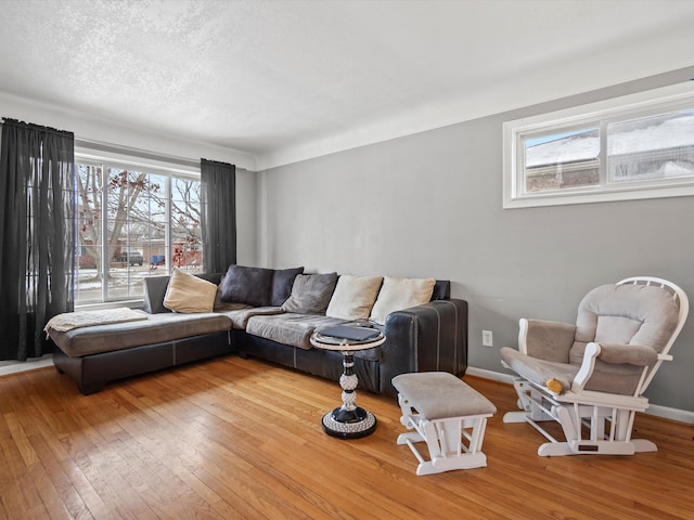 living room featuring wood-type flooring, a textured ceiling, and a wealth of natural light