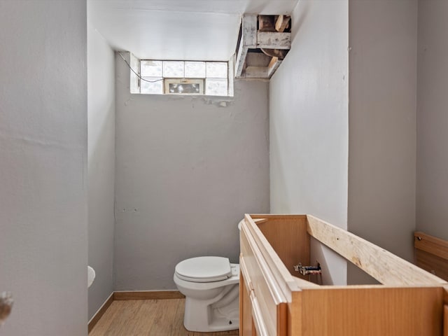 bathroom with hardwood / wood-style flooring and toilet