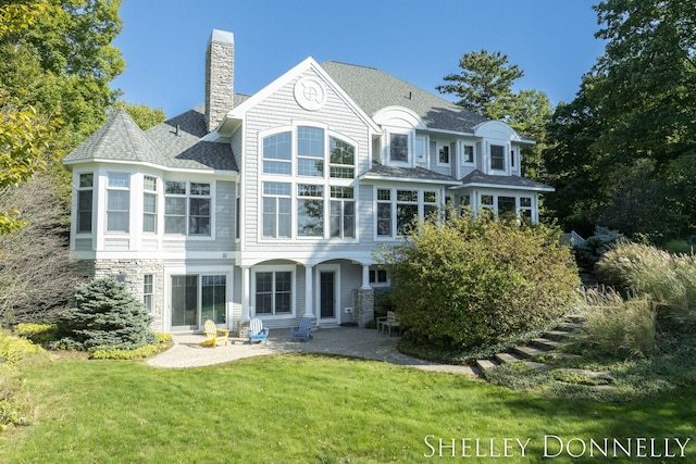 rear view of house featuring a patio and a yard