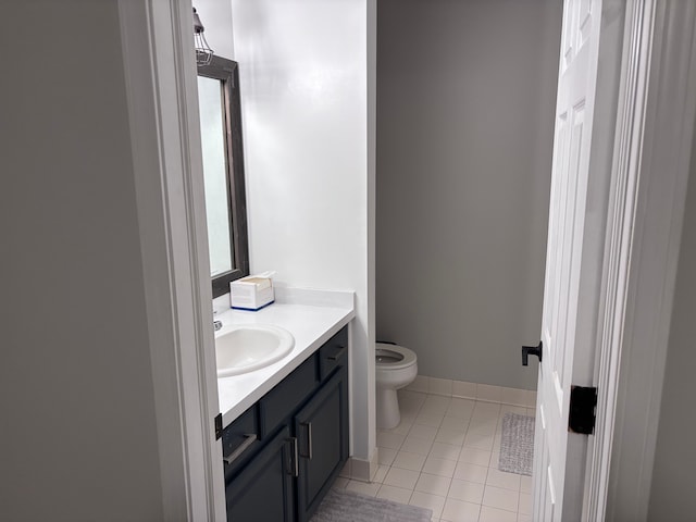 half bathroom with toilet, tile patterned flooring, baseboards, and vanity