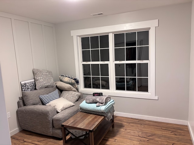 sitting room featuring wood finished floors, visible vents, and baseboards