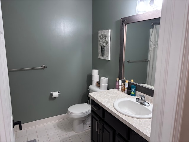 bathroom with tile patterned flooring, baseboards, vanity, and toilet