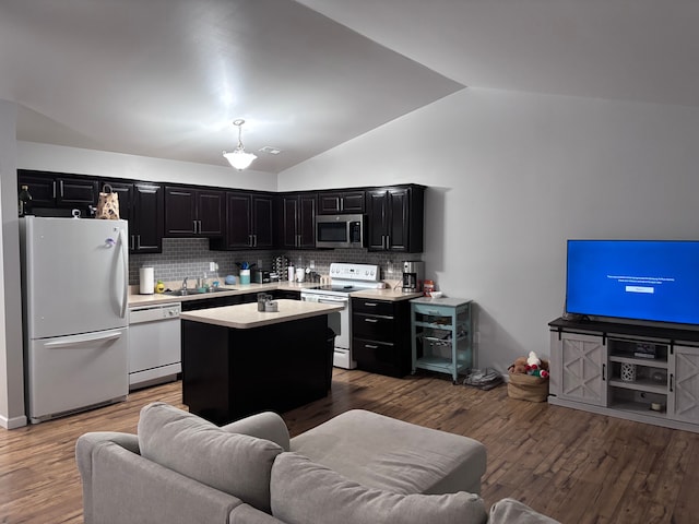 kitchen featuring white appliances, dark wood-style flooring, dark cabinets, a center island, and light countertops