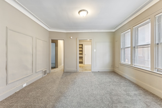 unfurnished bedroom featuring crown molding and light carpet