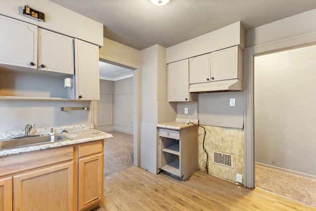 kitchen with sink, light brown cabinets, and light wood-type flooring