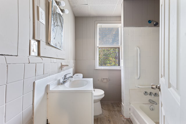 full bathroom with vanity, hardwood / wood-style flooring, shower / bathtub combination, and toilet