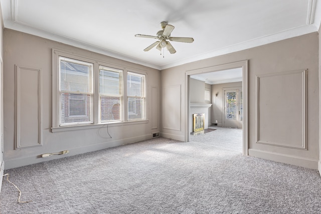 carpeted empty room featuring ceiling fan and crown molding