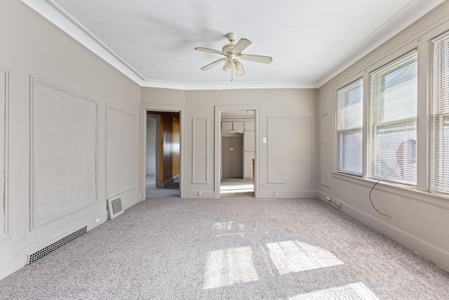 unfurnished bedroom with ceiling fan, carpet flooring, and crown molding