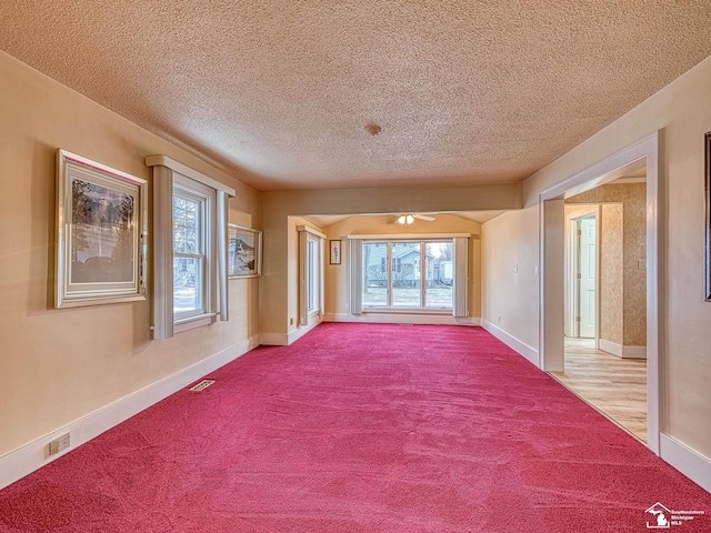 carpeted spare room with a textured ceiling and a wealth of natural light