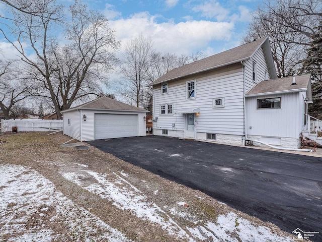 view of snow covered exterior with a garage and an outbuilding