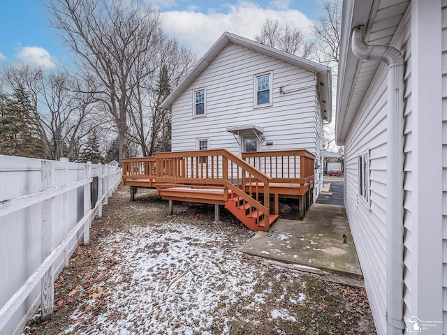 snow covered house featuring a deck