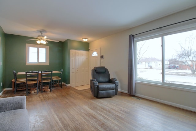 living room featuring ceiling fan and light hardwood / wood-style floors