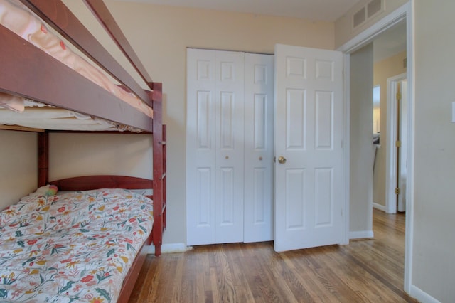 unfurnished bedroom featuring wood-type flooring and a closet