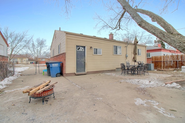 back of property featuring a patio area, a fire pit, and central AC