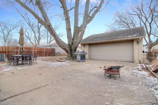 exterior space with a garage, an outdoor fire pit, an outdoor structure, and a grill