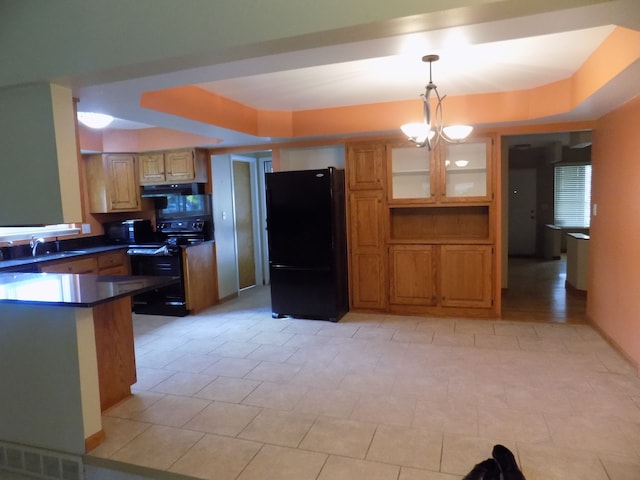 kitchen with sink, hanging light fixtures, a notable chandelier, black appliances, and a raised ceiling