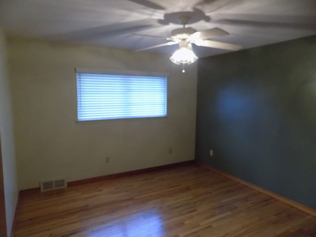 empty room featuring hardwood / wood-style floors and ceiling fan