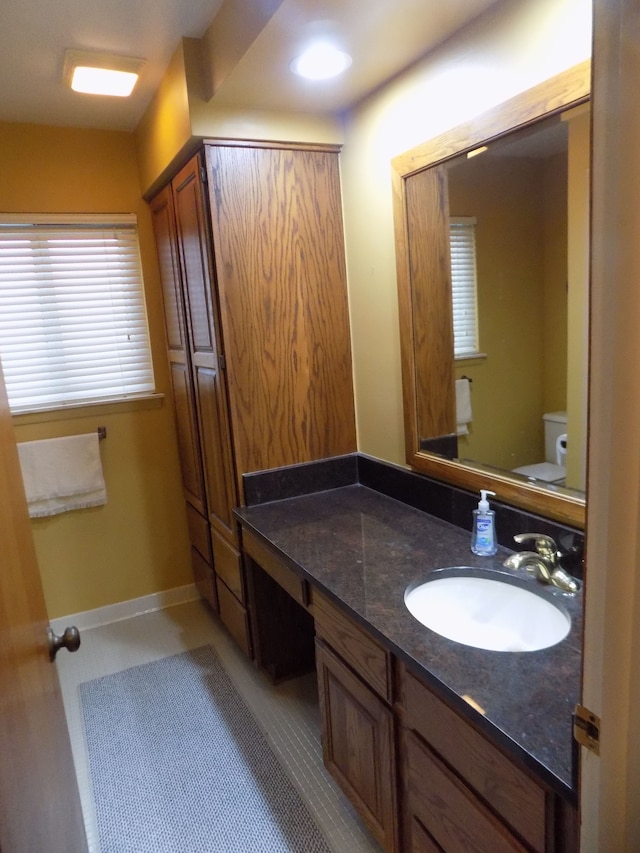 bathroom with vanity, toilet, and tile patterned flooring