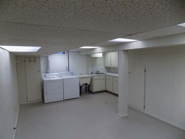 laundry area featuring cabinets, separate washer and dryer, and sink