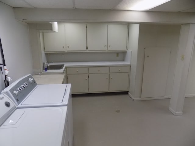 washroom with cabinets, sink, and washer and dryer