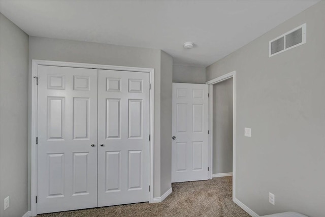 unfurnished bedroom with a closet and light carpet