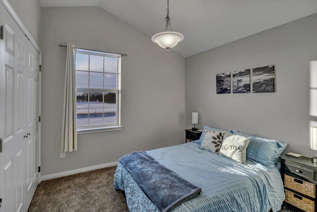 carpeted bedroom with a closet and lofted ceiling