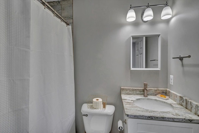 bathroom with toilet, vanity, and a shower with curtain