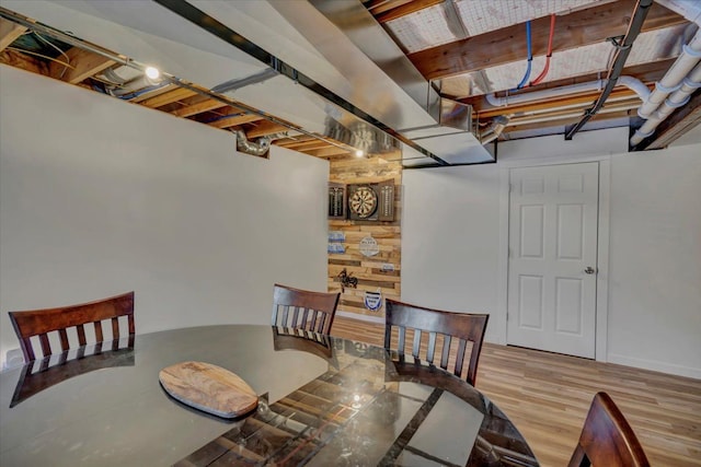 dining room featuring wooden walls and light hardwood / wood-style floors