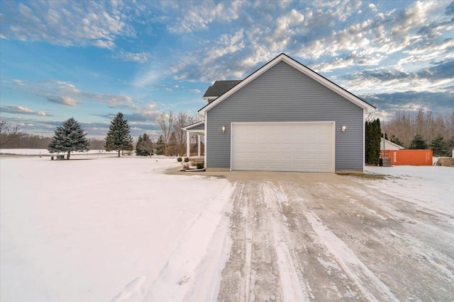 snow covered property with a garage