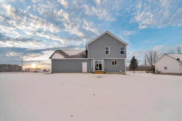 view of snow covered back of property