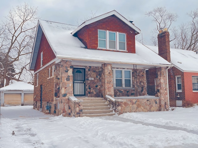 view of front of property featuring an outbuilding, a garage, and a porch