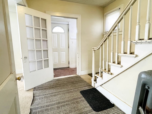 foyer entrance featuring carpet flooring