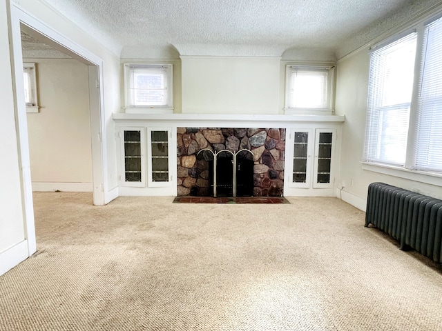 unfurnished living room featuring radiator, carpet floors, and a healthy amount of sunlight