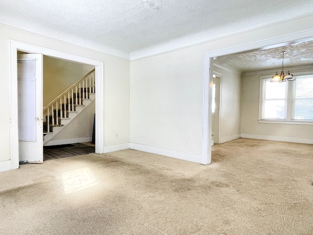 carpeted empty room with an inviting chandelier and a textured ceiling