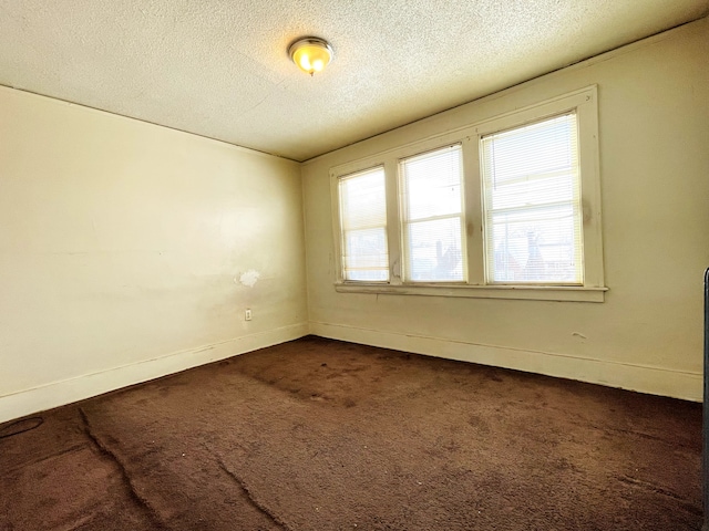 unfurnished room with a textured ceiling and carpet