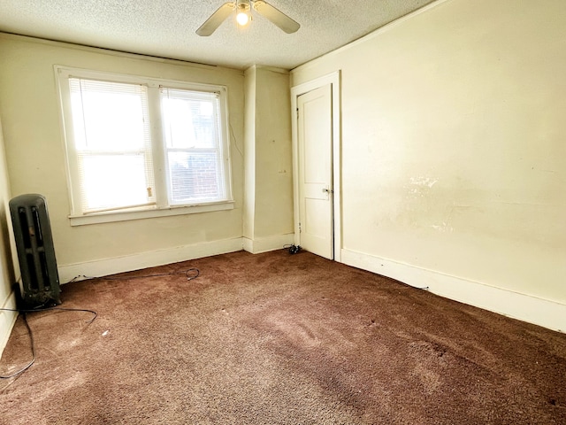 empty room featuring ceiling fan, carpet, and a textured ceiling