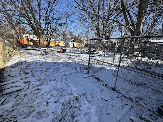 snowy yard featuring a storage shed