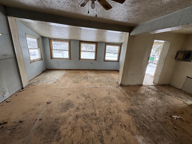 interior space featuring a textured ceiling, vaulted ceiling, and ceiling fan