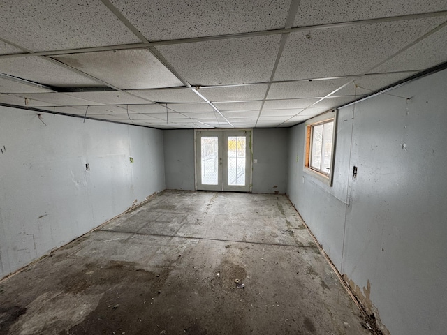 basement with french doors and a drop ceiling