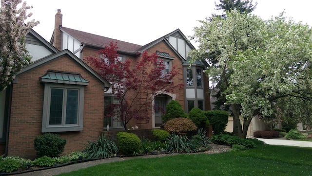 english style home featuring a front yard