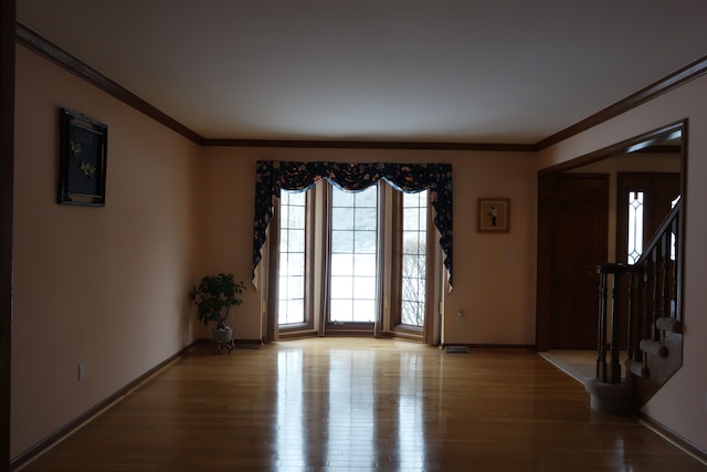 unfurnished room with crown molding and light wood-type flooring