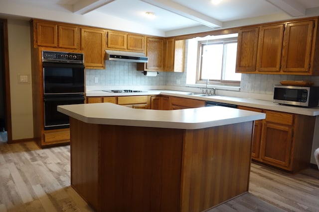 kitchen with beamed ceiling, light hardwood / wood-style floors, a center island, and double oven